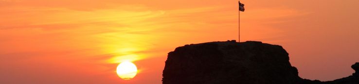 Perranporth beach Summer sunset with the Cornish flag on top of Chapel Rock
